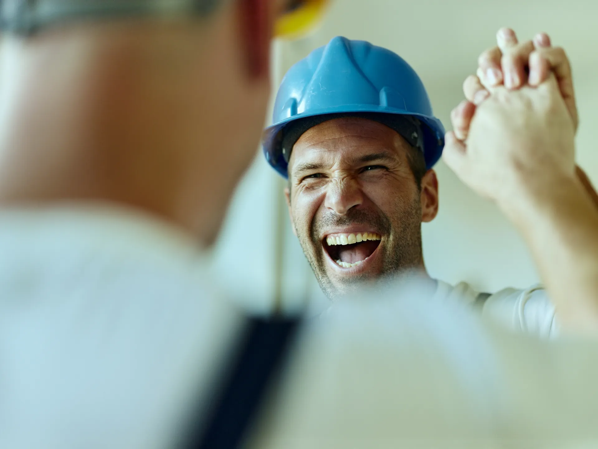 Handschlag eines glücklichen Mitarbeiters in einem Handwersunternehmen